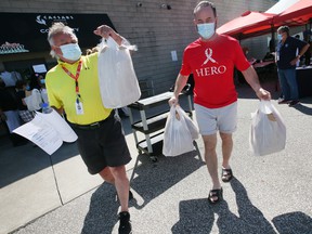 Ken Dalley, left, a volunteer with the VON Windsor-Essex and Rod Lynds with the Caesars Windsor Cares organization head out to deliver meals on Tuesday, June 21, 2022 at the Unemployed Help Center in Windsor.  Caesars donated $10,000 for the compassionate meal program.