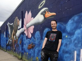 Mural artist Josh Harnack in front of his artwork located at 6316 106 St. in Edmonton.