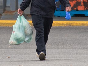 Shoppers leave the Real Canadian Superstore in Sunridge, Calgary with groceries in plastic bags on Wednesday, October 7, 2020.