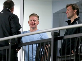 Daniel Alfredsson smiles while chatting with Pierre Dorion, left, and Luke Richardson in September 2015.