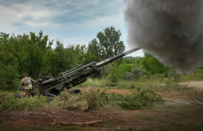 Ukrainian soldiers fire on Russian positions with an M777 howitzer.