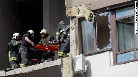 Rescue teams evacuate a person from a residential building damaged by a Russian missile attack in Kyiv, Ukraine, on June 26, 2022. 