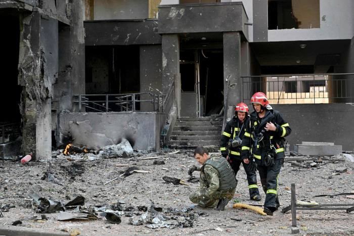 Rescuers outside a damaged residential building