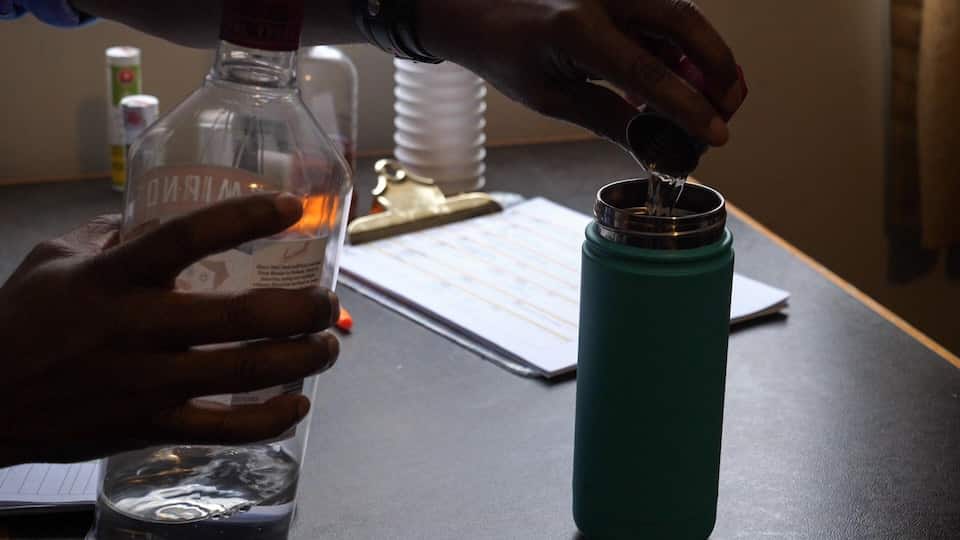 A man fills a goblet with alcohol.