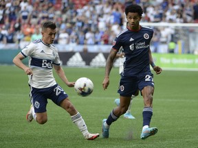 Vancouver Whitecaps midfielder Andres Cubas (20) challenges New England Revolution midfielder Dylan Borrero (27) during the first half at BC Place on Sunday.
